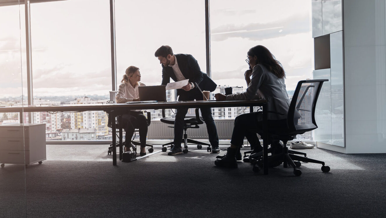 Creative business people working on project in modern office with panoramic view. Blurred background